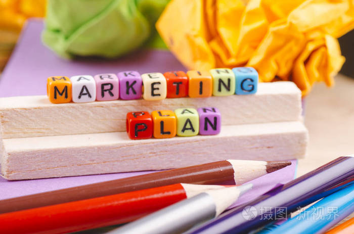 商业活动概念背景，木制桌上有文字营销计划的彩色立方体