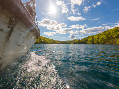 从水面上沿着湖巡游的船的侧视图.照片