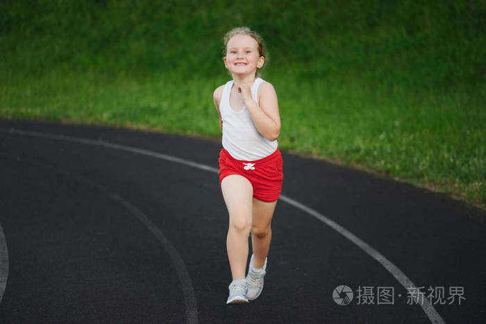 快乐的小女孩在体育场奔跑
