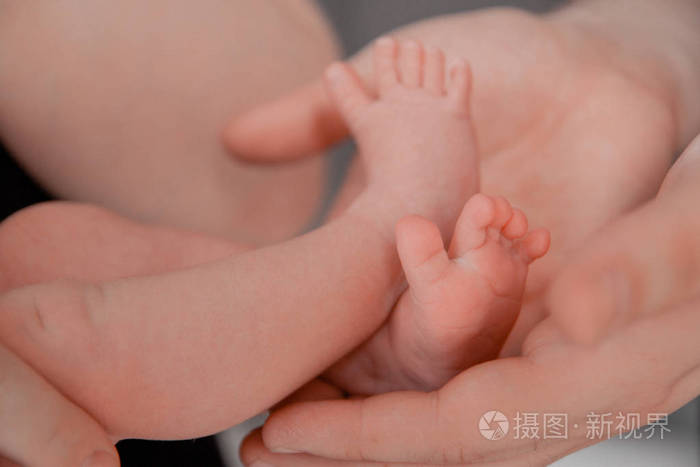 孕期产期准备和期望孕产分娩概念。新生婴儿脚在父母手中