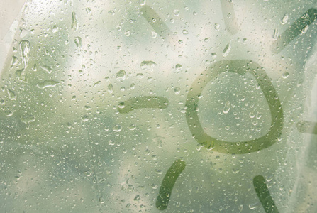 模糊的背景复制空间在半透明的雾状玻璃上画一条手指形状的太阳光.