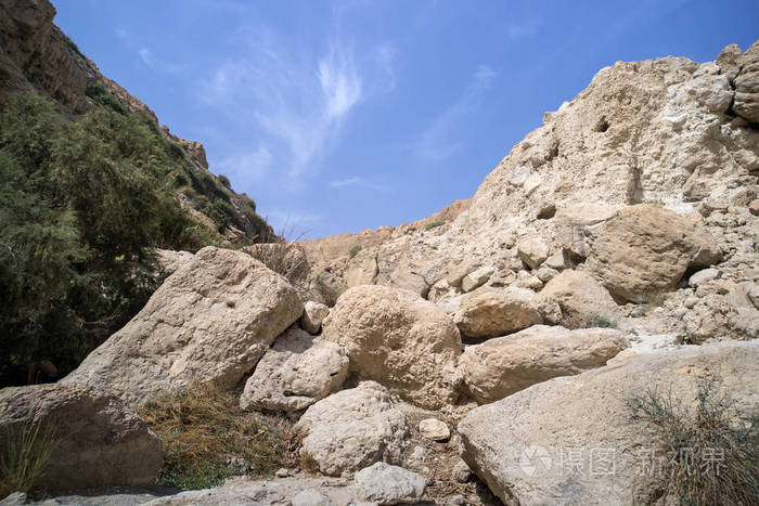 在蓝天下,光秃的石头和绿荫相对.有两块石头和天空的风景.山清水秀