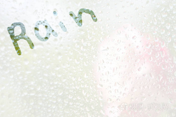 透明的薄雾玻璃上画一条手指形状的单词雨雨点的春雨在窗户上特写模糊