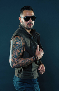 太阳手臂纹身有二头肌和三头肌的纹身男人.在未刮胡子的脸上纹身.