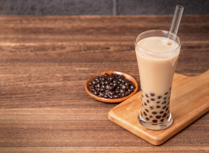 珍珠茶球台湾流行饮品-泡泡奶茶用木薯珍珠球在饮用玻璃和吸管上,木质