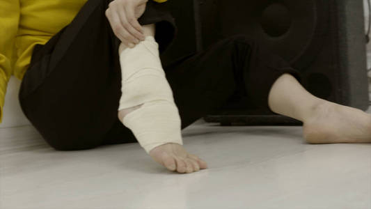 特写用弹力绷带包扎腿部的妇女.行动.