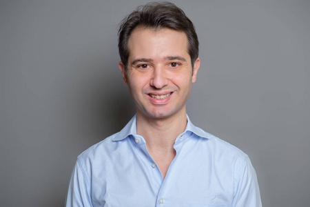 灰底蓝衬衫笑脸男肖像照片