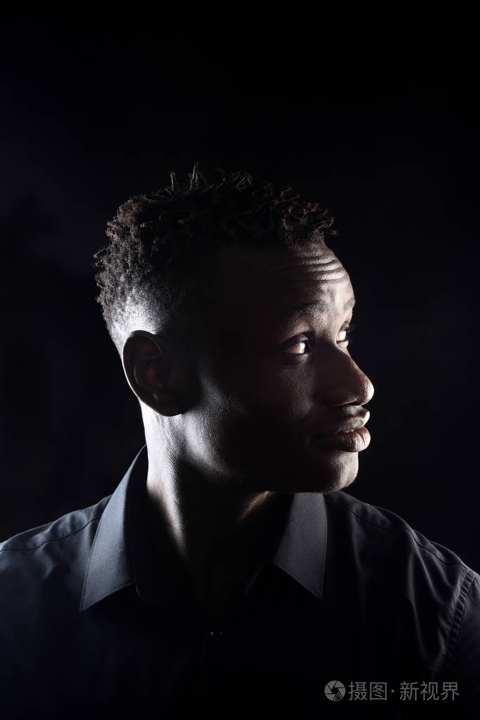一个黑人背景的非洲男人的肖像侧面