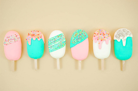 平铺排列各种冰淇淋棒棒糖.柔和色调设计.平铺照片