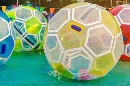 在主题公园的游泳池里,孩子们在水上玩着巨大的泡泡球照片