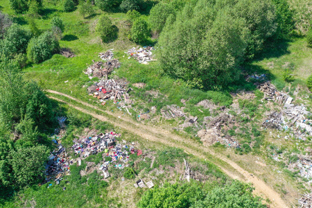 大型垃圾填埋场,生活垃圾,塑料和其他东西之间的绿色森林沿草地和道路