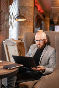 看在中计算机上网本成功人士.舒适的咖啡馆里年轻商人的画像.