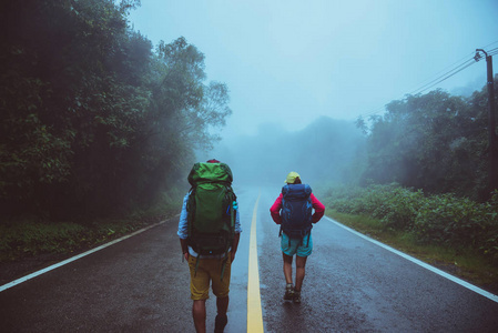 走在路上.快乐地旅行大自然.在雨雾中.在雨季.照片
