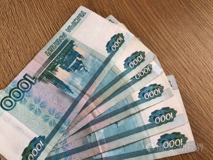 木制背景上面值1000卢布的俄罗斯纸币照片-正版商用图片2kenl7-摄图新