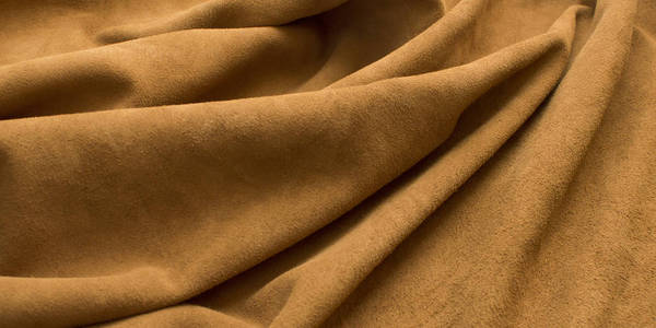 棕色翻毛皮,皱褶,卷边,卷边织物的背景照片