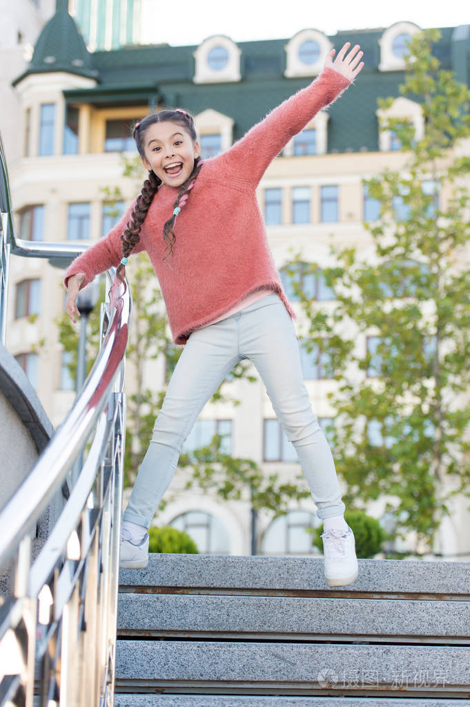 跑下楼梯快乐精力充沛的孩子穿着便装在台阶上跳跃精力充沛的小女孩留