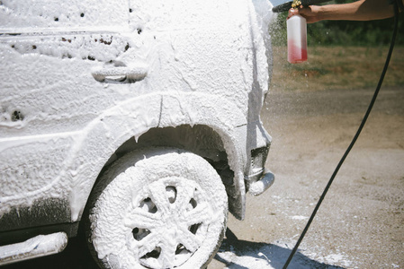 一名男子在汽车上喷高压清洗剂图片