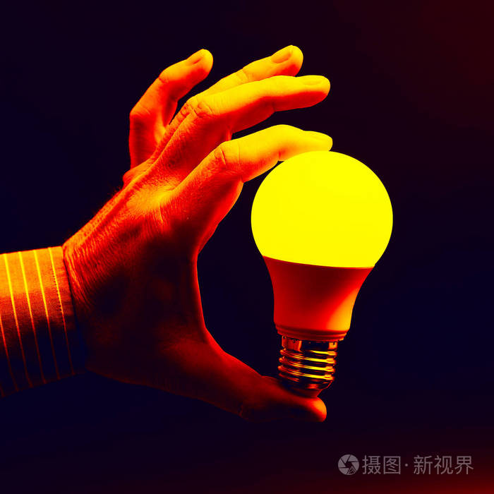 在黑暗的背景上用手握住内含的led灯