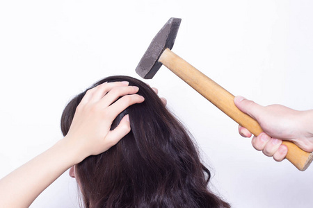 脑震荡一个年轻女孩拿着她的头附近有一把锤子,头痛的概念是用锤子击