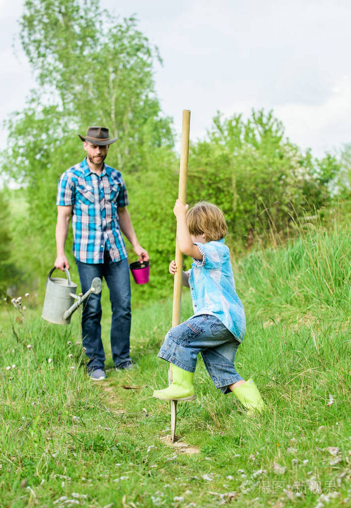 地球日快乐.用铲子挖土.新生活.土壤和肥料.小男孩帮助父亲耕作.