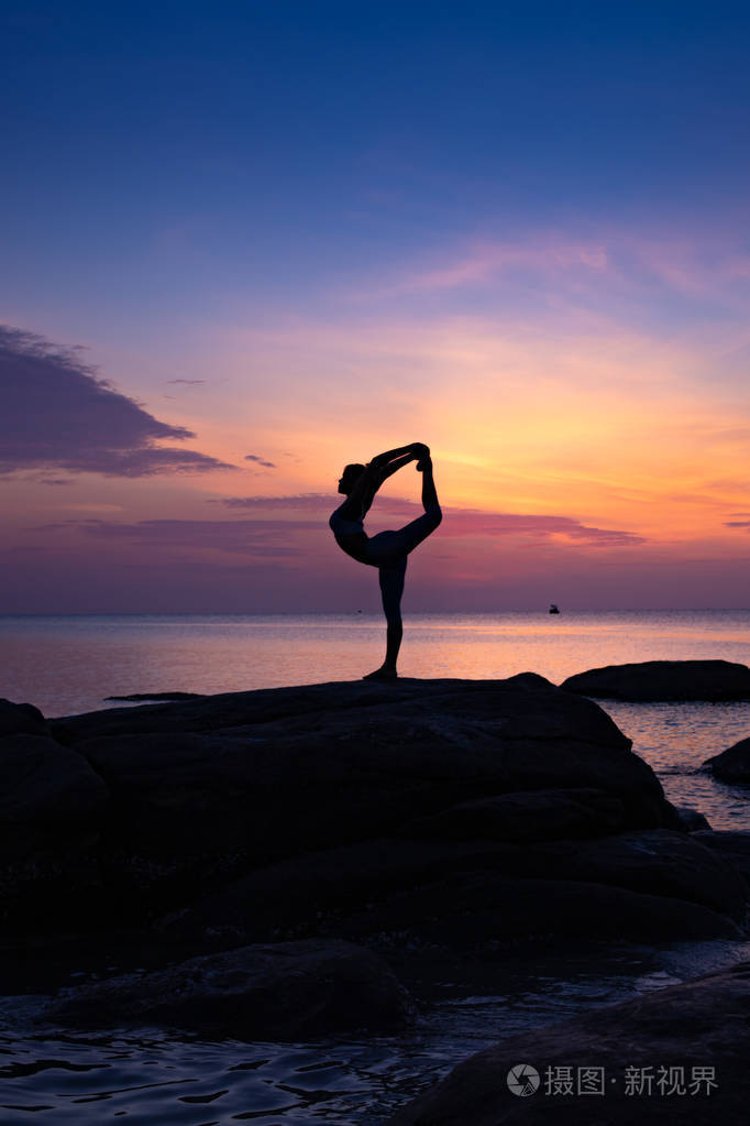 亚洲女孩在海滩上练习瑜伽日出的一天