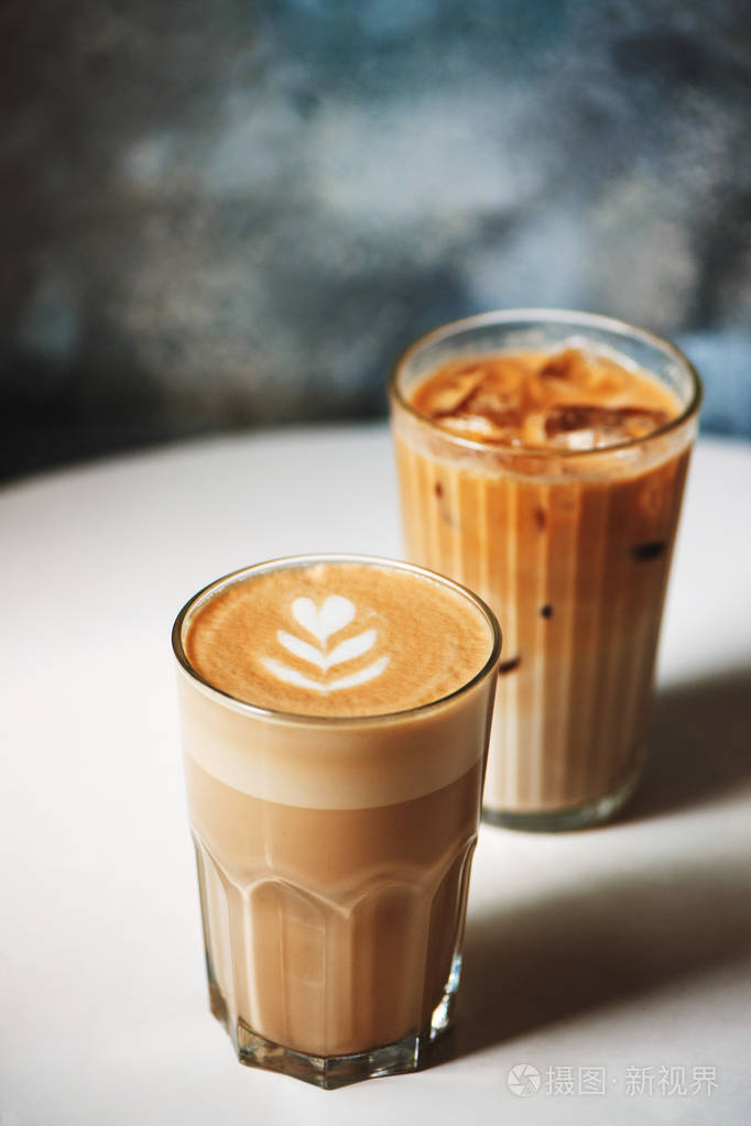咖啡厅桌子上的咖啡杯里的拿铁和冰拿铁
