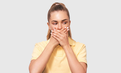 默默守护的签名画像惊骇的年轻女子捂着嘴用手捂着嘴,看着一边,孤立在