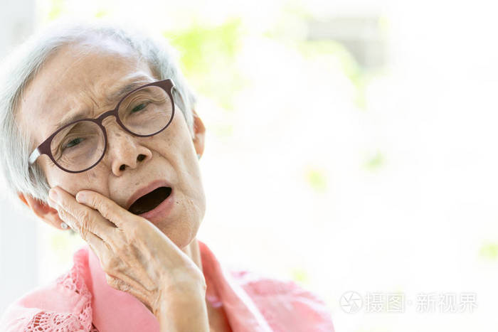 亚洲老年妇女患牙痛蛀牙感觉疼痛女性老年人用手捂住脸颊牙齿有问题