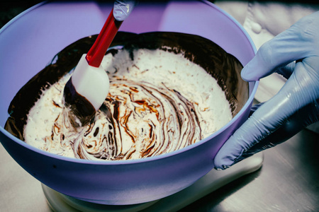 奶油蛋糕混合巧克力乳霜掼奶油和手搅拌器指已提到的人男孩采用指已