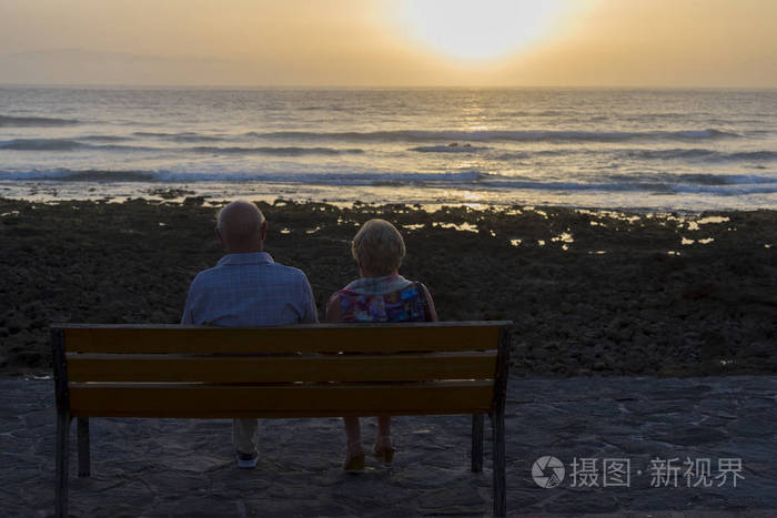 老人们坐在海边看日落