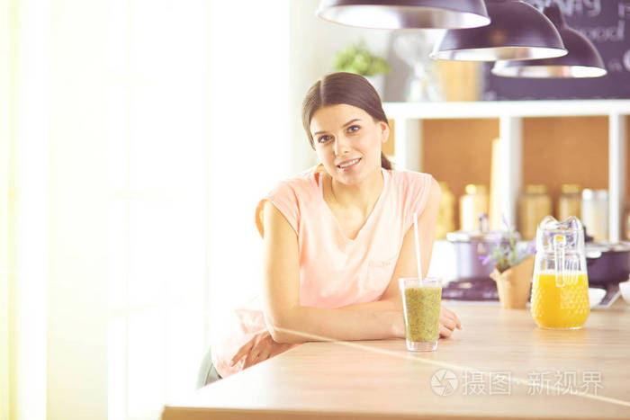 坐在厨房桌子上的年轻女子