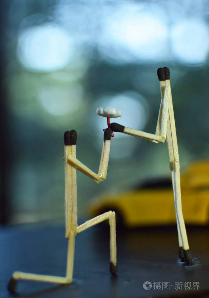 男孩用火柴棒向女孩献花的创意摄影