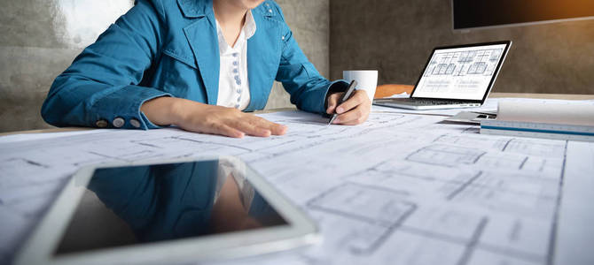 女建筑师设计师在设计图上画画.照片