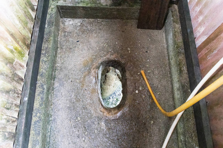 关闭地面上的传统厕所洞.粪便掉进河里照片
