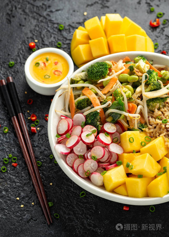 亚洲式素食沙拉碗配毛豆蔬菜炒菜全麦米饭藜麦芒果块辣椒酱