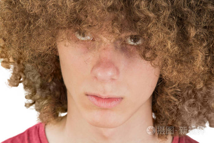 一个年轻的欧洲卷发男子的画像他严肃地看着他的长发眼睛抬起来很浓密