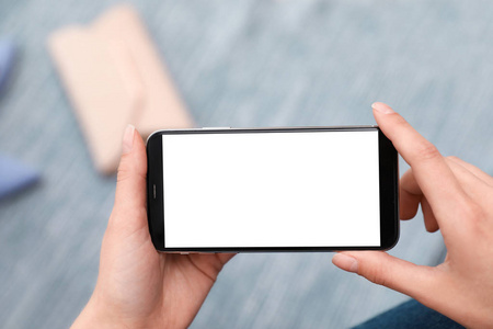 女人拿着智能手机,在室内黑屏,手特写.文本空间照片