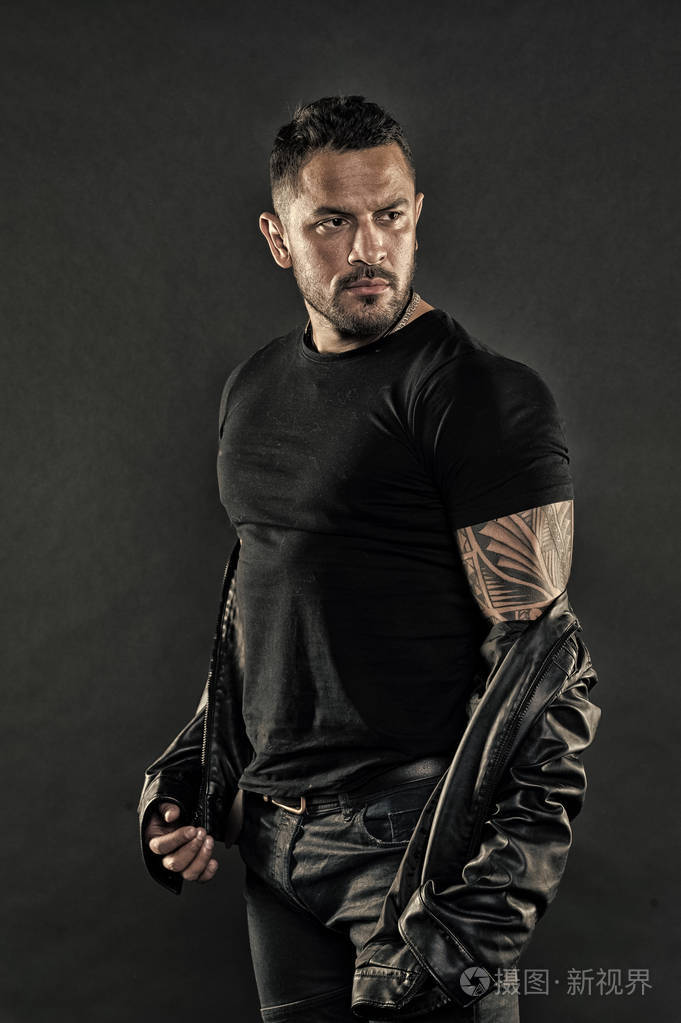 胡子男在强壮的手臂上纹身.脸上留着阳刚的胡子.男子气概和力量.