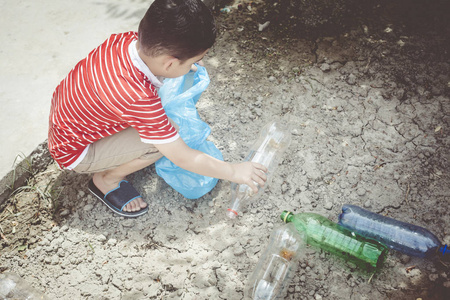 收集塑料瓶的小男孩.小孩拎着垃圾袋.自由空间照片