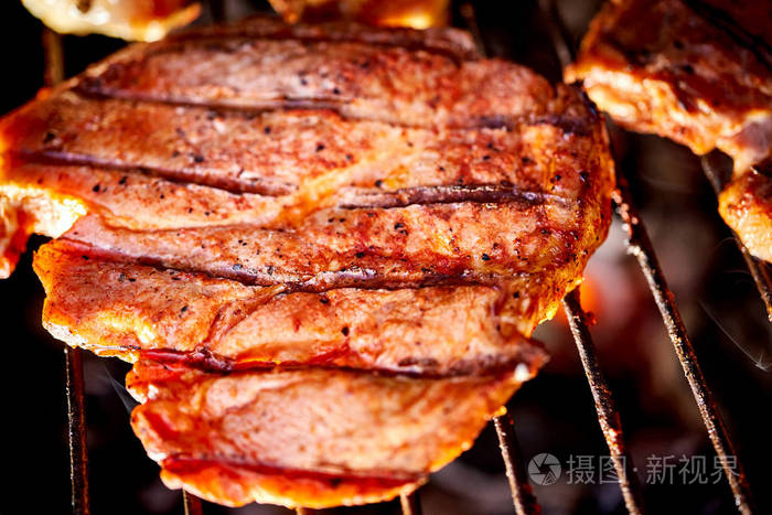 多汁的牛肉排在烧烤架上在花园里烧烤
