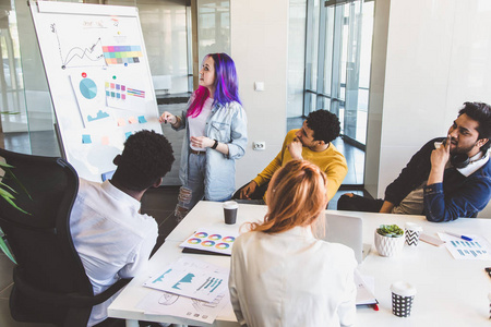 商务男男女女围坐在办公室的桌子旁,面带微笑.