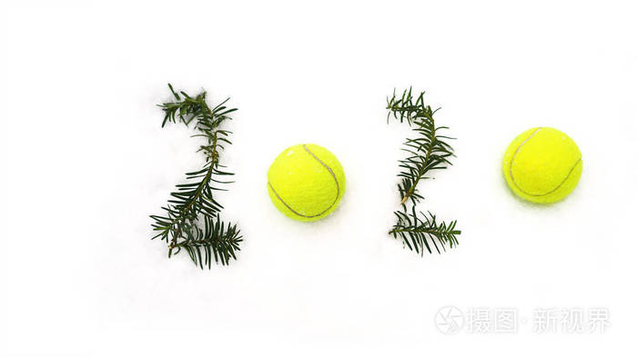 网球圣诞节和2020新年概念网球和冷杉树枝在白雪，孤立。