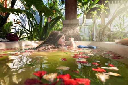 草药浴缸洗草药浴晒太阳的女孩照片