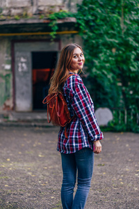 一个女人站在楼前回头看照片