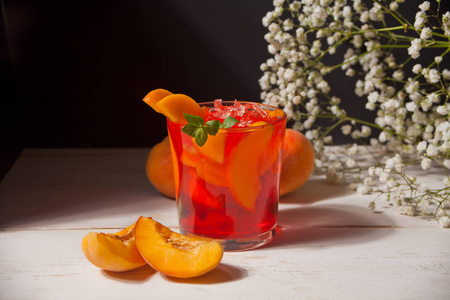 一杯新鲜的自制桃子甜冰茶或鸡尾酒,柠檬水薄荷.清凉的冷饮.夏季聚会.