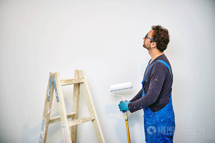 工人粉刷房屋内的墙壁装修修复