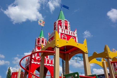 多云的蓝天背景下,孩子们游乐场的城堡塔顶照片