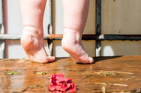 一个小女孩光着身子站在浴室的椅子上.浴室水槽用高脚椅架照片