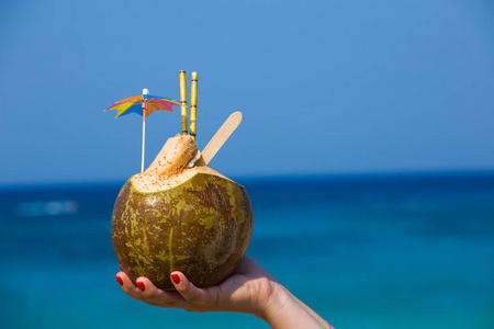 手里拿着伞和管子的椰子照片