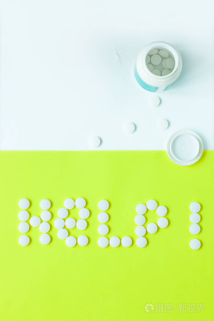 黄色背景上的帮助字形状的药丸平铺俯视极简风格